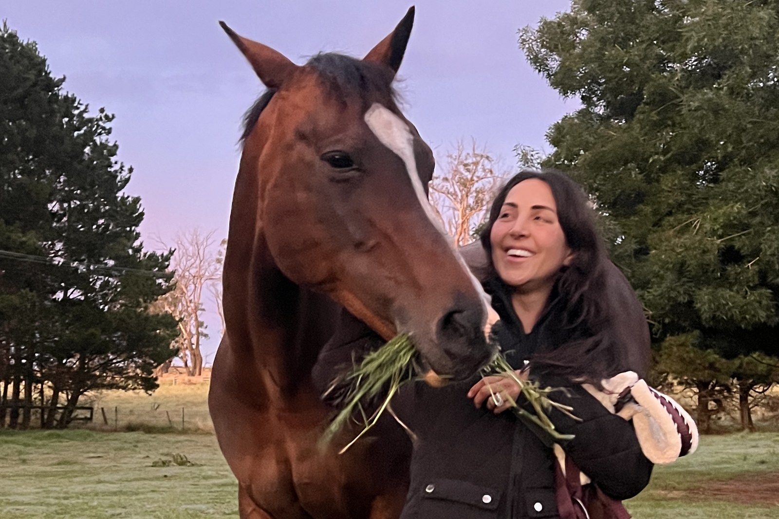 Eden laughing as her horse Missy eats from her hand at sunset